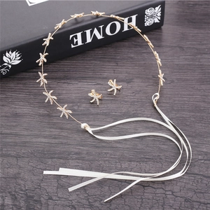 Close-up of golden starfish headpiece and clip earrings set with sparkling rhinestones