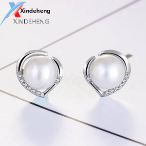 Macro shot of S925 silver pearl stud earrings with sparkling crescent moon accents
