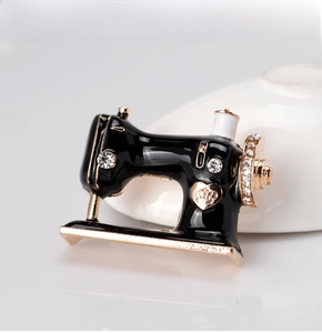 Macro view of vintage sewing machine brooch with black enamel and sparkling crystals
