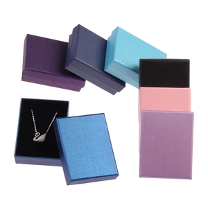 Multi-colored vintage kraft paper jewelry boxes with a swan pendant necklace inside