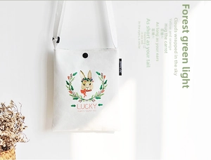 Detail of canvas crossbody bag with rabbit illustration and natural lighting effect