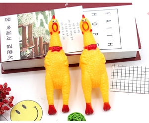 Flat lay view of two yellow screaming rubber chickens with red bowties on a decorative desk