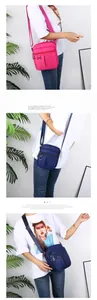 Detail view of multi-pocket nylon crossbody bag with adjustable strap and metal zippers