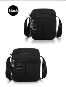 Close-up showing multiple metal zippers and d-rings on a black nylon crossbody bag