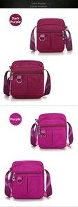 Detail view of small nylon crossbody bags in deep purple and purple colors with zippers