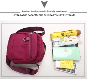 Spacious burgundy nylon crossbody bag shown with a water bottle and umbrella for scale