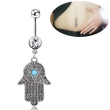 Macro shot of silver Hamsa Hand belly ring with turquoise stone and sparkling crystals