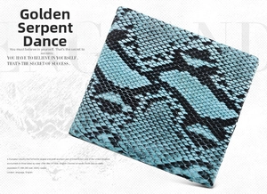 Detailed view of teal and black faux snake leather material with realistic scale texture