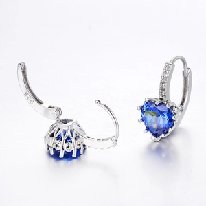 Detailed macro view of S925 sterling silver heart earrings with blue cubic zirconia stones