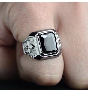 Macro detail of men's vintage silver ring with black onyx stone and cross carving