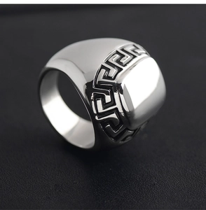 Detailed close-up of vintage stainless steel ring with Greek key meander patterns