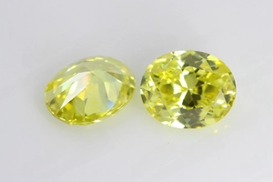 Vue macro de deux zircons ovales jaunes avec une taille à facettes très détaillée