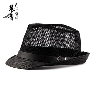 Detail of black straw fedora hat featuring a matte leather band and silver buckle