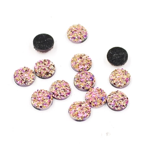 Close-up of 8mm round pink and gold druzy resin rhinestones with flat black backs