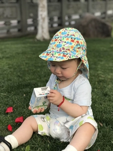 Macro shot of cartoon print baby sun hat with neck protection flap and seaside pattern