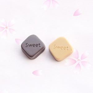 Detailed view of large resin chocolate charms with Sweet text for DIY keychain making