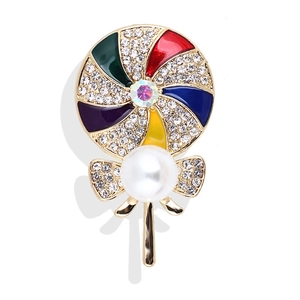 Detail of colorful lollipop brooch with sparkling rhinestones, enamel, and a white pearl