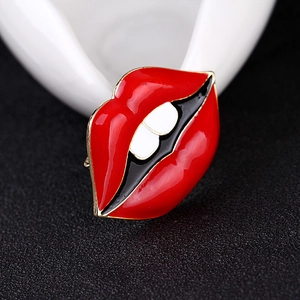 Détail macro d'une broche lèvres rouges en émail avec bords dorés et style pop art