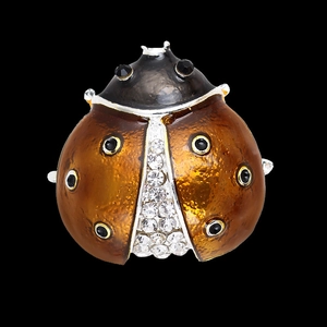 Macro view of ladybug brooch featuring amber enamel with rhinestone inlay and black spots