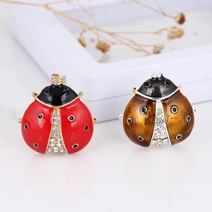 Cute ladybug brooches in red and brown with rhinestones and enamel on white background