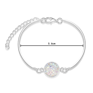 Close-up of silver bangle with 5.6cm diameter and colorful iridescent crystal pendant