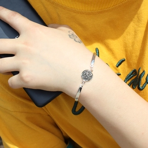 Detailed view of silver round bracelet featuring black crystal stone on wrist