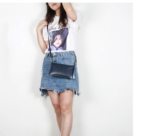 Dark blue leather crossbody bag with long strap shown on model against white background