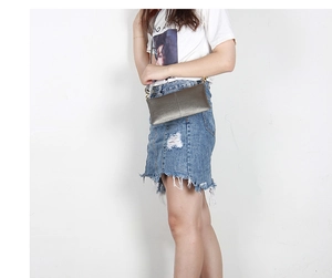Detail of a gunmetal metallic leather envelope clutch with a minimalist crossbody strap
