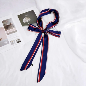 Macro detail of navy silk narrow scarf with red and white stripes on fabric background