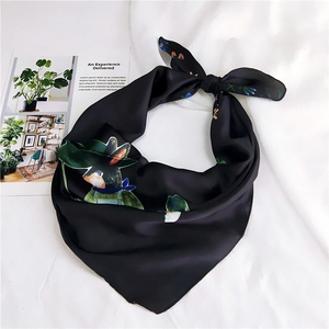 Detailed close-up of a black silk scarf with cute rabbit print on white fabric
