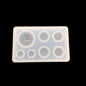 Detalle de molde de silicona translúcida con 7 huecos geométricos para resina epoxi