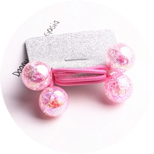 Detailed view of pink crackle beads on an elastic hair tie displayed on a silver card