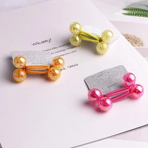 Three colorful elastic hair ties with sparkly glitter bone charms on display card