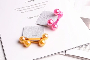 Detail of pink and yellow elastic hair ties with textured glitter beads on card