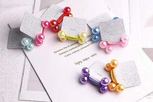 Detailed view of colorful elastic hair bands with glossy beads on silver glitter cards