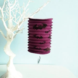 Detailopname van de paarse papieren accordeon lantaarn met een vleermuis motief hangend.