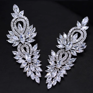 Gros plan de boucles d'oreilles plume avec zircons AAA en forme de feuilles argentées