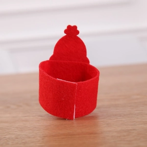 Detail of red felt Santa napkin ring with crown design on a light wood background