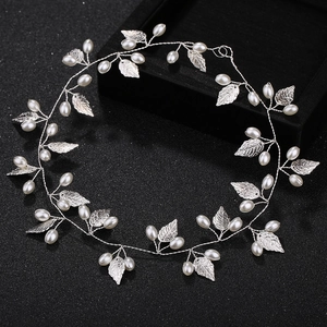 Elegant silver bridal headband with metallic leaves and pearls on a sleek black background