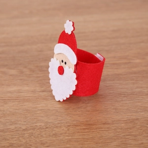 Felt Santa Claus napkin ring in red and white on a wooden background for Christmas decor