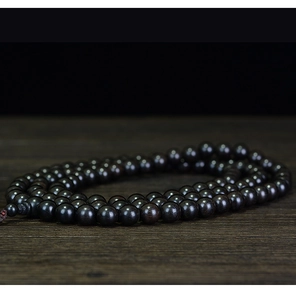Detailed macro shot of 108 sandalwood prayer beads with natural wood grain texture