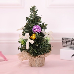 Mini tabletop Christmas tree with green needles, linen base and purple ball topper