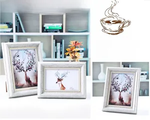 Detail of white vintage faux wood picture frames with elegant reindeer art prints