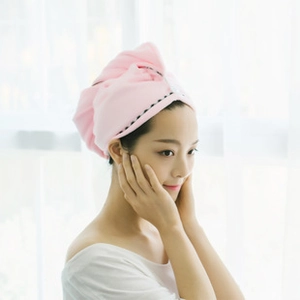 Side view of a pink coral fleece hair drying towel with button closure on a model
