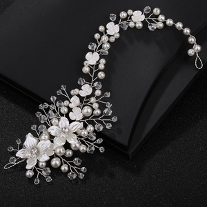 Detailed view of silver wire floral headband with ceramic flowers, pearls, and crystals