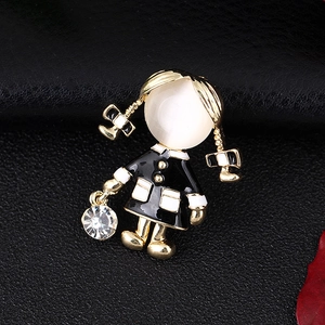 Close-up of a golden girl brooch with white cat eye stone and dangling crystal detail