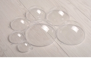 Palline di Natale trasparenti in plastica acrilica di varie dimensioni su legno