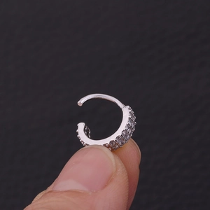 Macro di anello al naso in argento con micro-zirconi su sfondo scuro strutturato