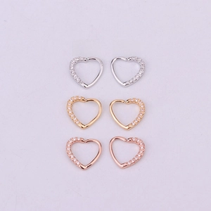 Flat lay of heart-shaped zircon clicker rings in silver, gold, and rose gold finishes