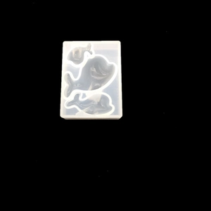 Dettaglio dello stampo in silicone traslucido con tre forme di delfini per resina